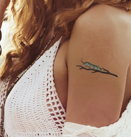 Tatuaje temporal de oruga con mariposa que brilla en la oscuridad